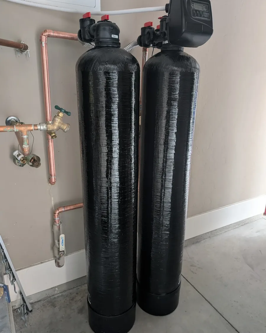 Two whole-house water treatment tanks with copper supply lines and a bypass, installed in a garage