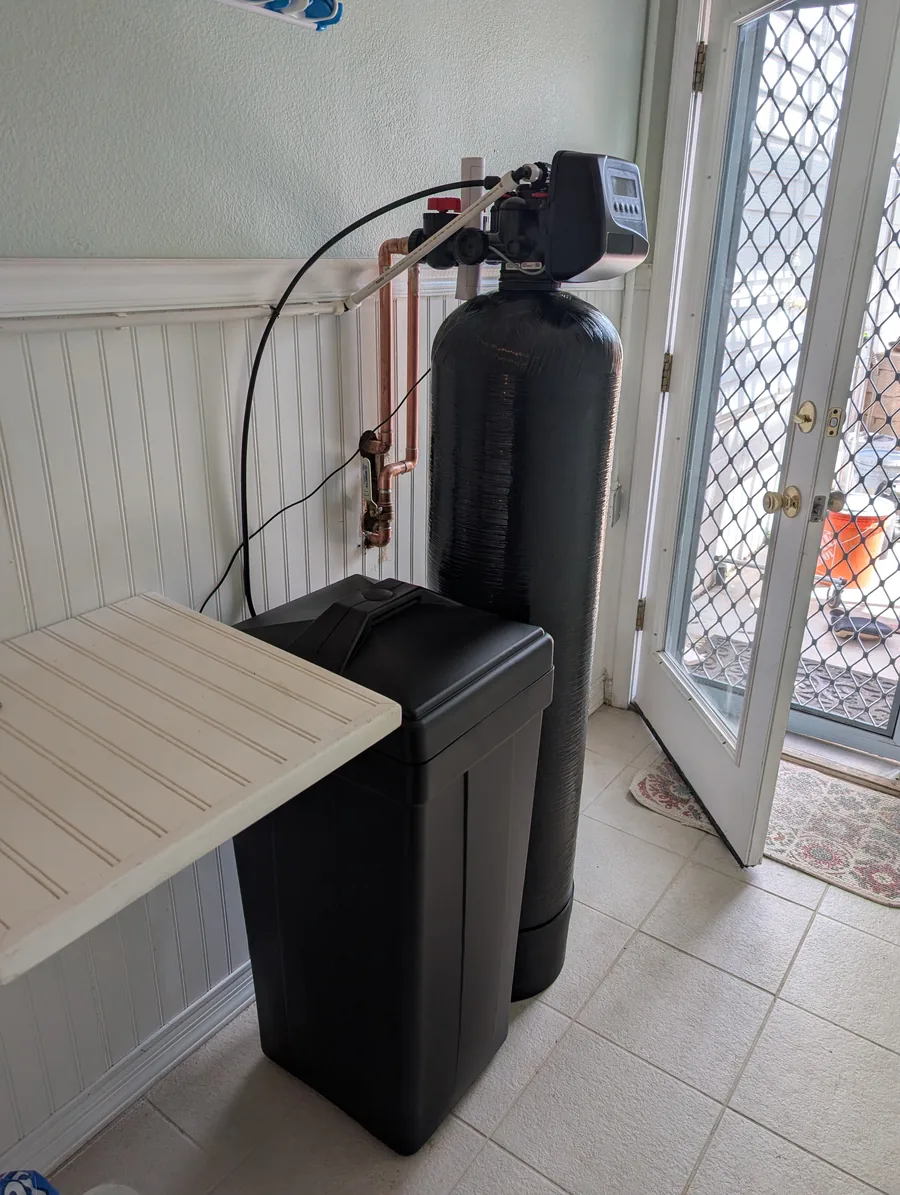 Water softener and brine tank installed beside a laundry room door