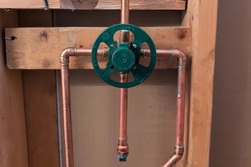 Copper supply lines and a shutoff valve roughed in between wall studs on a CreekWell job in Yavapai County